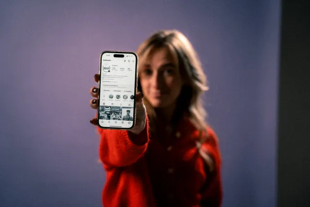 Redacteur Danielle houdt een telefoon in haar hand waarvan het beeldscherm op zwart-wit staat.