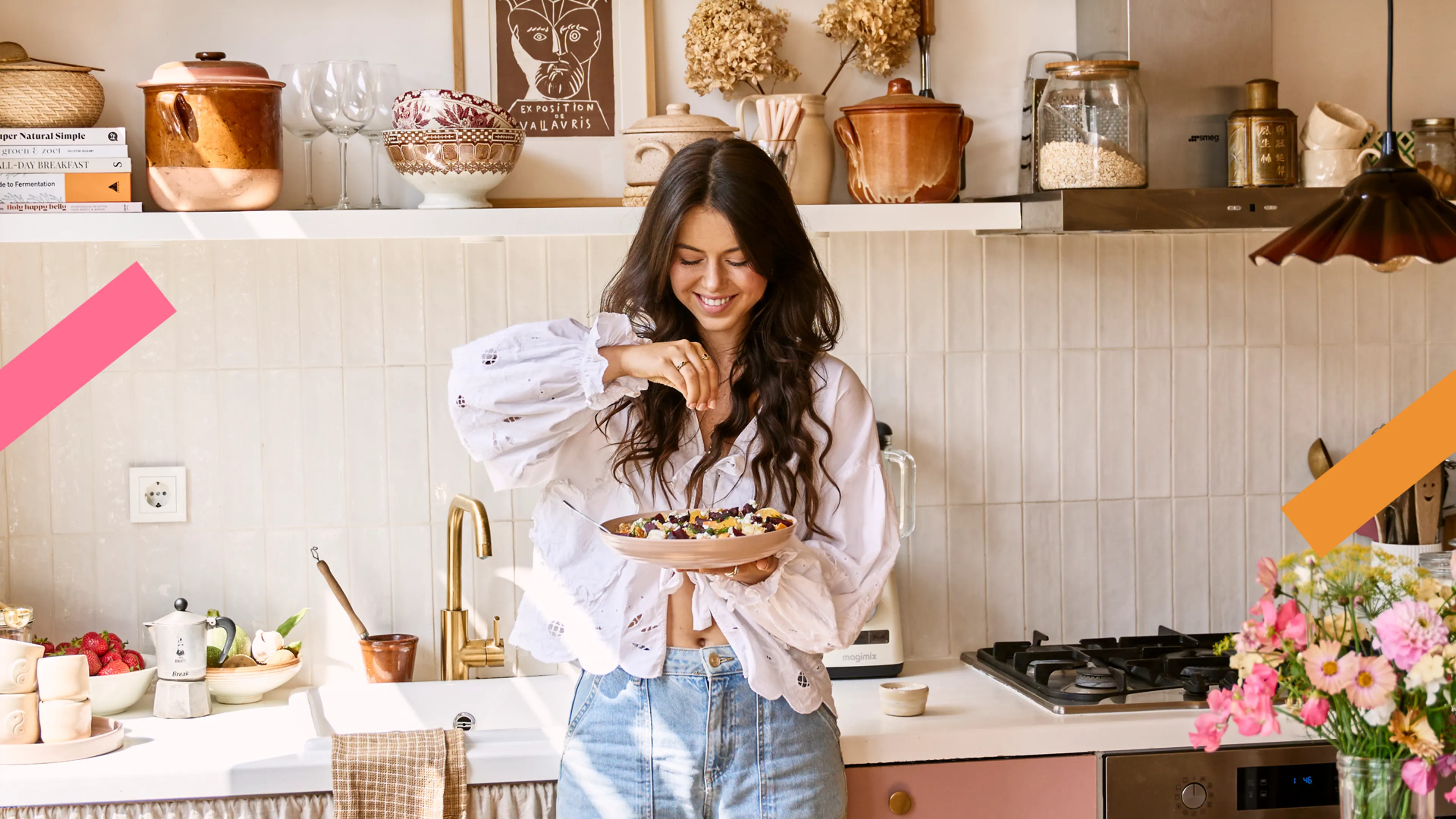 Food influencer Sanne staat met een bord eten in haar hand in een stijlvolle keuken.