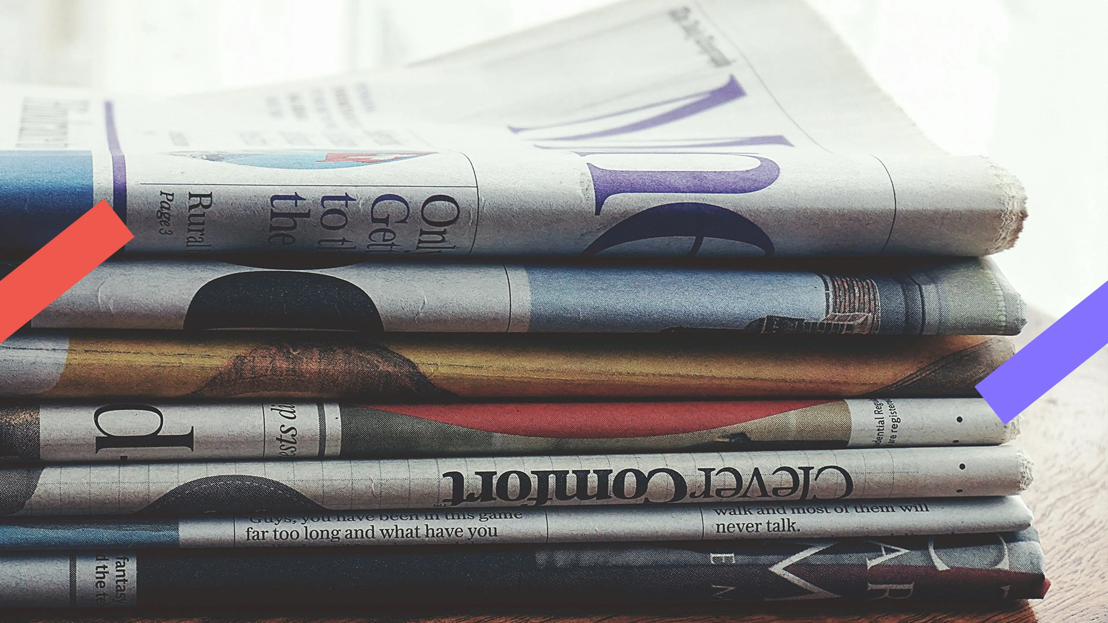 Een stapel kranten liggen op een tafel.