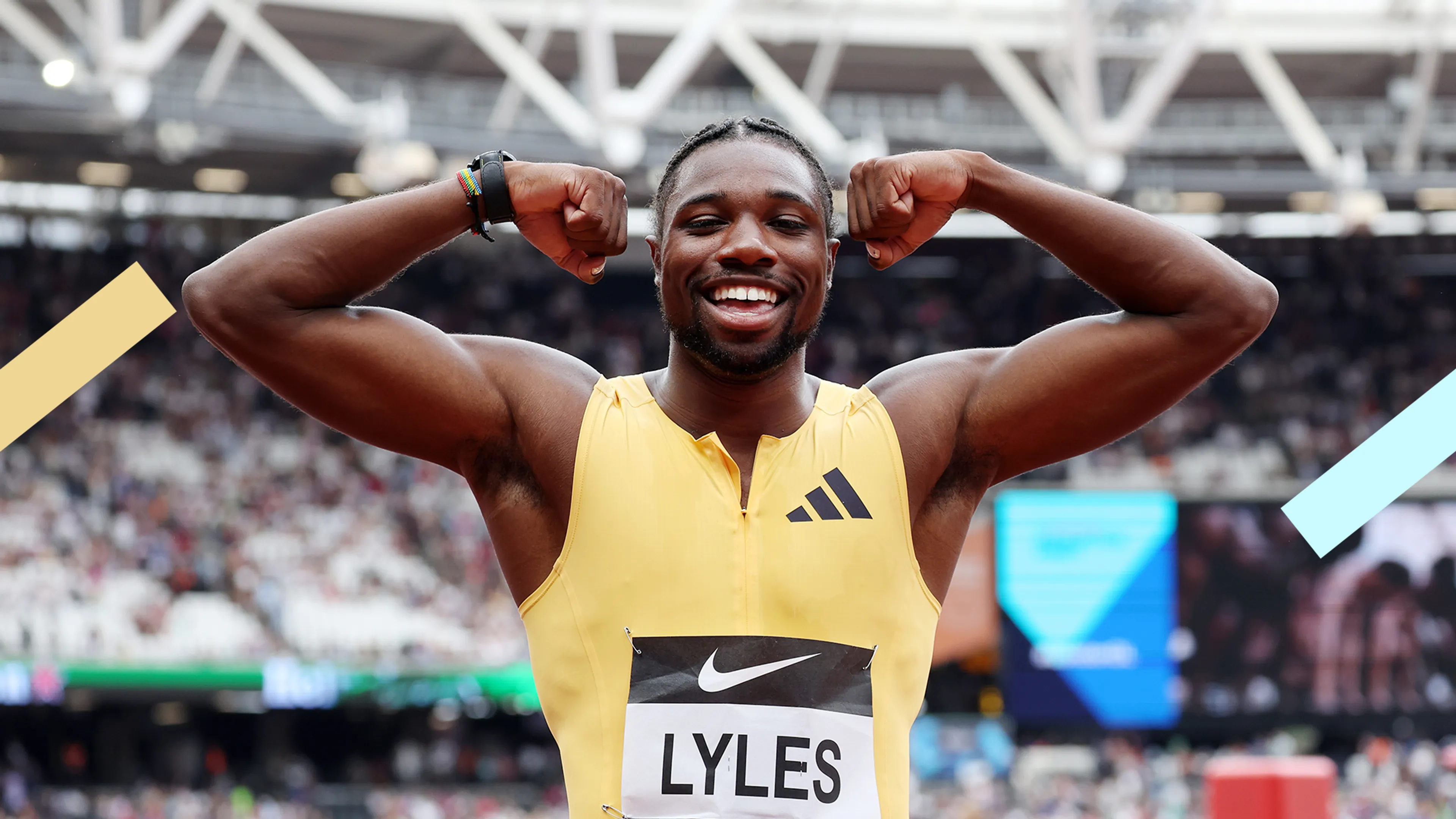 Sprinter Noah Lyles laat zijn spierballen zien en lacht in de camera. Hij draagt een geel pak.