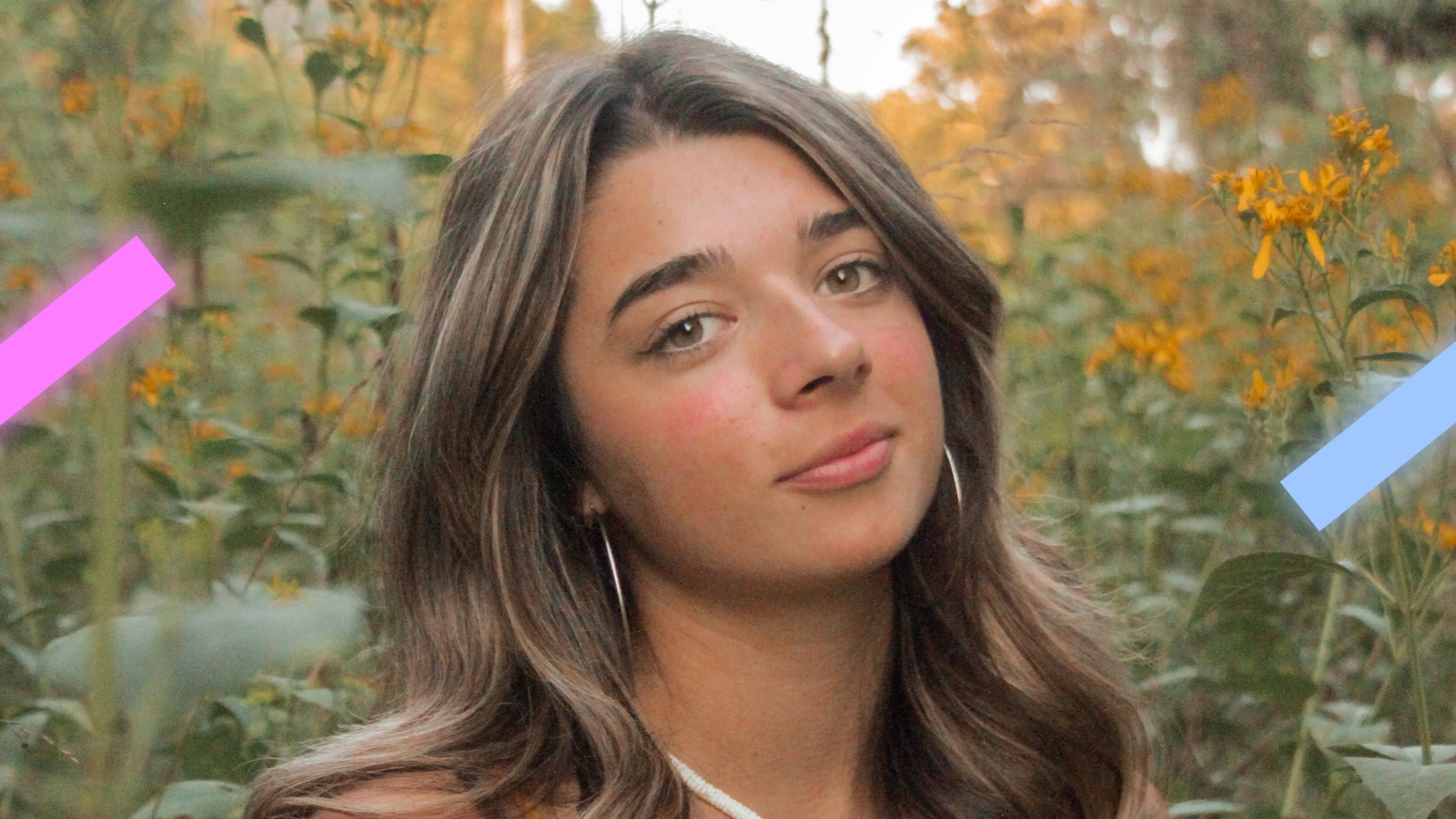 Een vrouw van 18 jaar met de naam Cleo kijkt met neutrale in de camera. Ze staat in een groene omgeving.