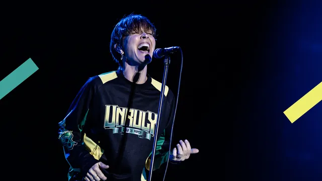 Zangeres Anouk die zingt en luchtgitaar speelt.