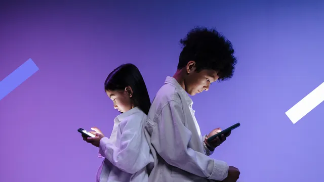 Twee jonge tieners kijken naar hun telefoon.