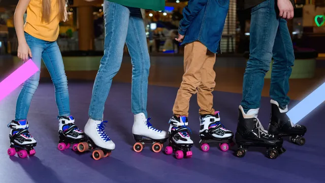 Vier tieners die op rollerskates staan en met z'n alle naar rechts rollerskate.
