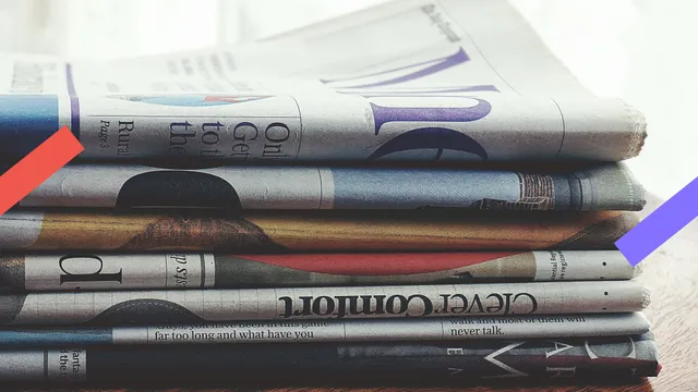 Een stapel kranten liggen op een tafel.