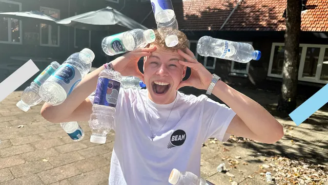 Redacteur Jelte kijkt in de camera terwijl hij een hele zak statiegeldflessen over zich heen gestort krijgt.